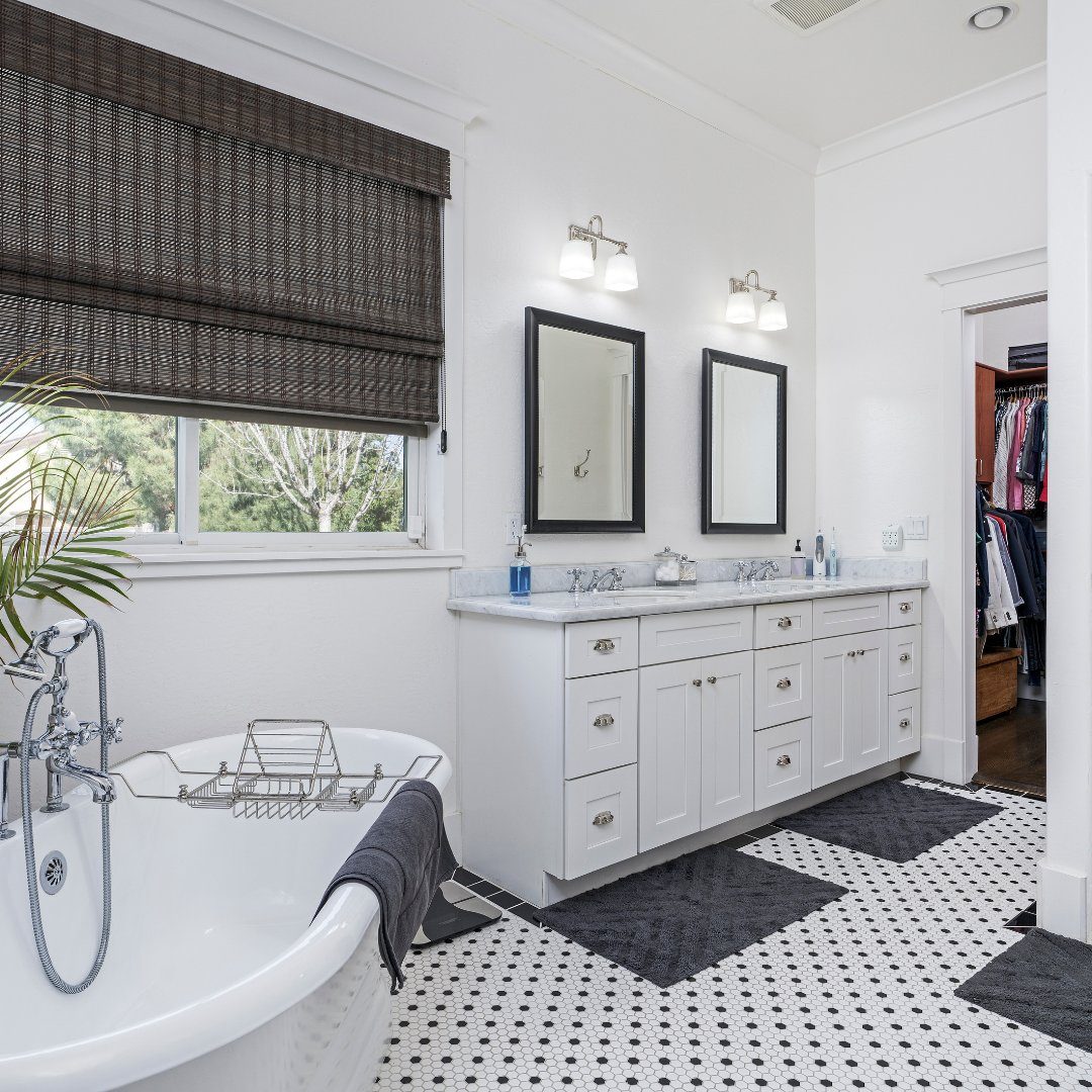 Renovated bathroom with grey marble tile and freestanding tub