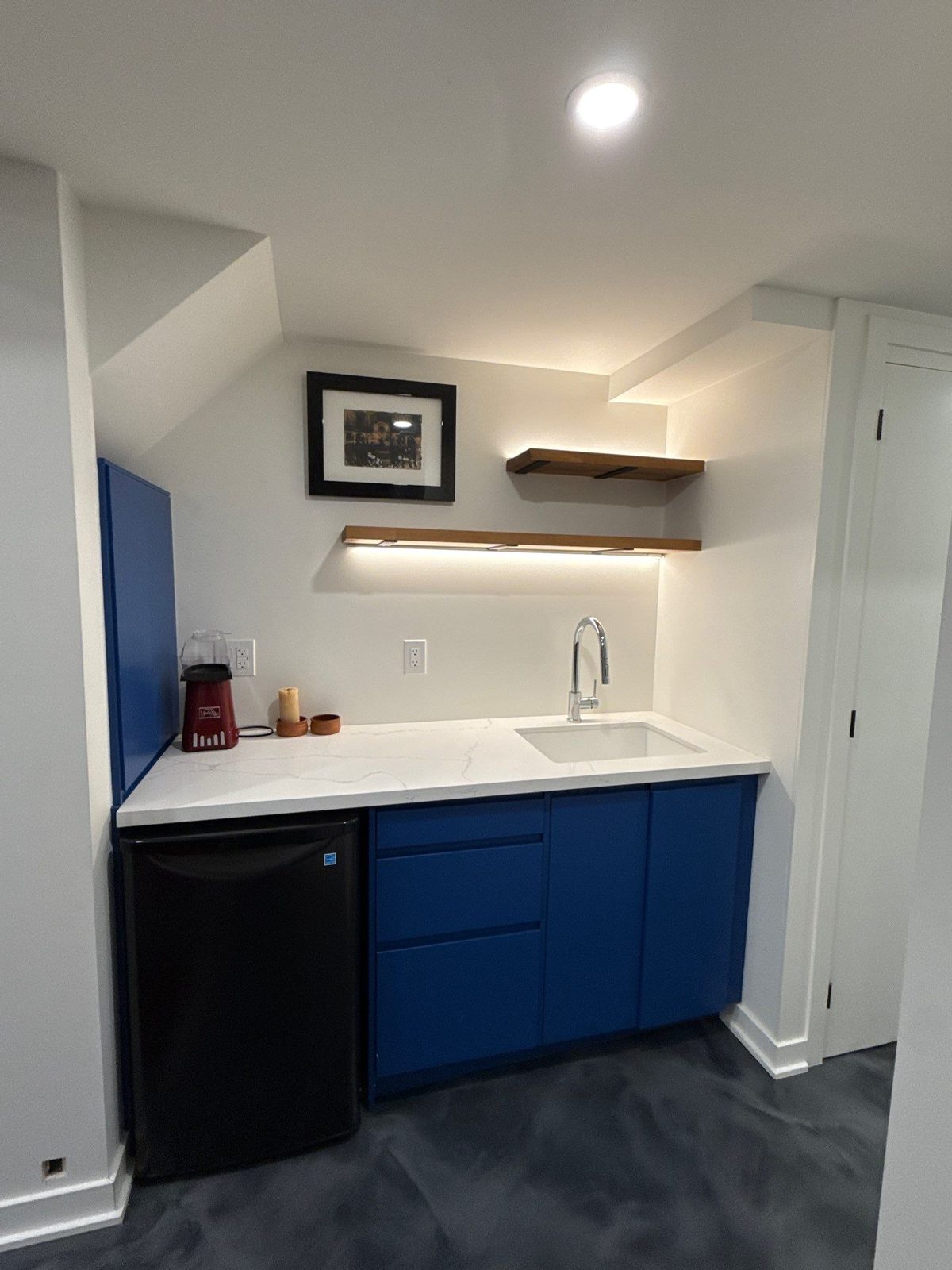 Basement wet bar with blue cabinets