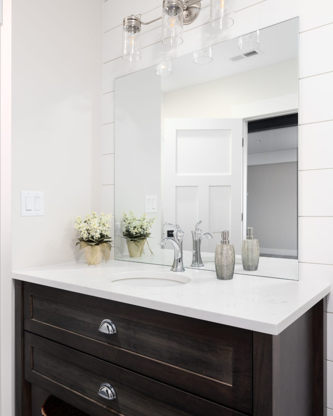 Powder room with shiplap wall and dark vanity